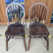 A pair of hoop back spindle turned elm seated chairs.
