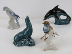 A Poole Sea Lion figurine, together with a Poole Dolphin and two ceramic birds,