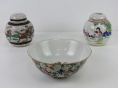An Oriental bowl having black ground with pink and green floral design upon, character mark to base,