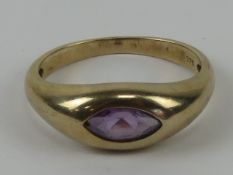A 9ct gold amethyst ring, the marquise cut amethyst a good purple hew in rub over setting,