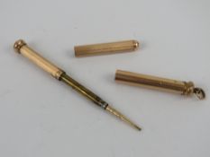 A gilded metal propelling pencil having chatelaine loop to top.