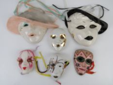 A quantity of decorative wall masks including an enamelled brass example. Six items.
