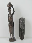 A carved African hardwood figurine of a woman standing 31cm high,