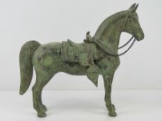 A 19th century cast metal horse in Eurasian saddle and bridle, 24cm high, 28cm in length,