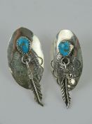 A pair of Native American sterling silver and turquoise earrings having feather charm upon,