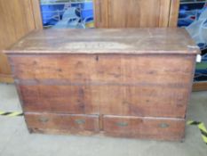 A plank-top pine mule chest, lid lifting to reveal compartment within.