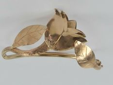A bespoke 9ct rose gold hinged bangle having three dimensional rose and leaves upon,