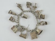 A HM silver charm bracelet with a quantity of large size charms upon including; miners lamp,