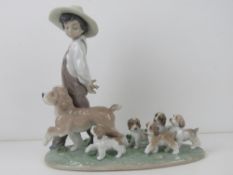 Lladro figurine 6828 'My Little Explorers' a boy walking with dog and five puppies following behind,
