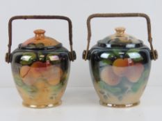 Two ceramic pearlescent wafer / biscuit barrels each with wicker handle and fruit design upon.