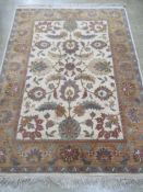 A good heavy woollen and silk floral rug in muted greens and browns measuring 212 x 156cm.