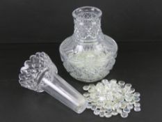 A lead crystal heavy cut glass two sectional lily vase, containing a quantity of glass beads,