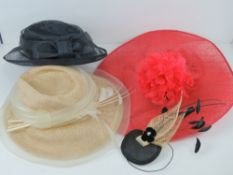 Three ladies hats in navy, cream and red by various designers.