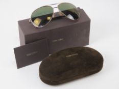 A pair of Tom Ford Sunglasses in case with outer packaging and polishing cloth.