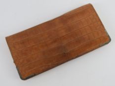 A vintage leather crocodile skin purse or clutch bag having hallmarked silver corner bracing,