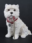 A figurine of a Westie with collar holdi