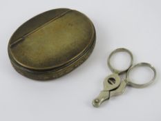 A brass snuff box of oval form with hing