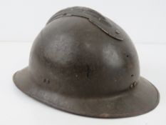 A French 1939-1943 helmet having liner and chin strap, badges removed.