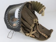 A WWII c1940s babys gas mask having rubber hose.