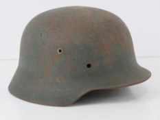 A WWII German helmet, liner deficient.