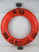 A HMS Marlborough life preserver ring having mounting hooks attached.