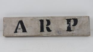 A wooden ARP sign 'found on door behind wall in Northampton'. 35 x 8cm.
