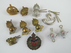 A quantity of assorted cap badges, some brass,