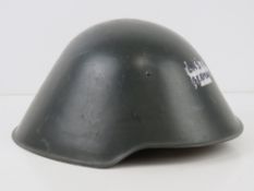 A late 20thC East German helmet marked within III/57, having chin strap and liner.