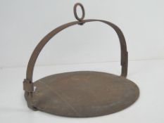 An antique wrought iron fireside skillet having hoop top with eyelet, 30cm dia.