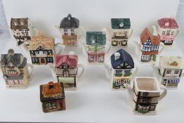 A quantity of assorted ceramic teapots in the form of shops and houses.