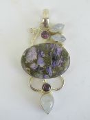 A large and impressive purple agate pendant having moonstone and amethyst coloured stones in