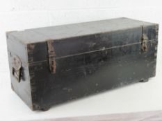 A black painted lidded trunk with clasps and end handles, 82 x 32 x 37cm.