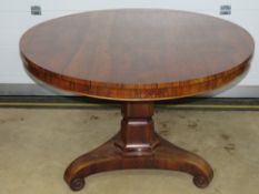A Victorian circular rosewood breakfast or loo table raised over a hexagonal column upon triform