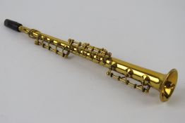 A miniature brass clarinet in case, approx 16cm in length.