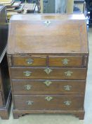 A good short late Georgian oak fall front bureau having two short over three long graduating