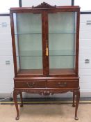 A 1930s walnut glazed display cabinet having twin glass shelves within and silk lined back,