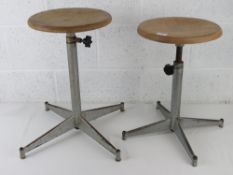 Industrial school; two X based metal stools each with adjustable circular tops,