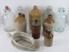A quantity of assorted stoneware jugs and glass demi-john jugs.
