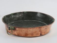 A copper pan having brass hanging hook, a/f, 32cm dia.