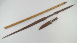 A decorative dagger in carved wood and brass sheath,