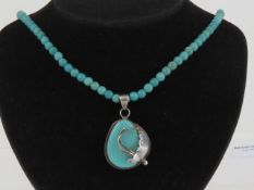 A floral silver and turquoise pendant, having large teardrop cabachon in frame stamped 925 approx 4.