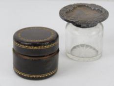 A leather and brass travelling inkwell opening to reveal captive sprung lid and glass bottle within