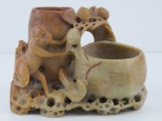 A carved soapstone brush pot featuring a