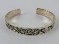 An HM silver bangle having floral decora
