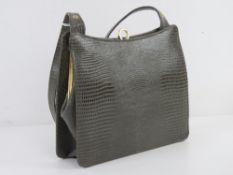 A vintage leather faux reptile skin hand