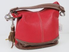 A red and brown Paula Rossi handbag with