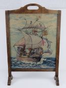 A vintage fire screen having Naval themed wool work within, 49cm wide, 74.5cm high.