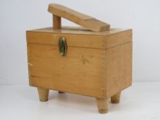 A c1960s shoe shine box containing a quantity of shoe brushes within.