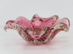 An art glass bowl in the form of a four leave clover, pink ground, having bubble pattern throughout.