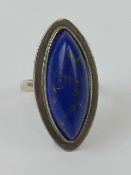 A lapis lazuli cocktail ring, the large marquise shaped cabachon having good gold coloured veining